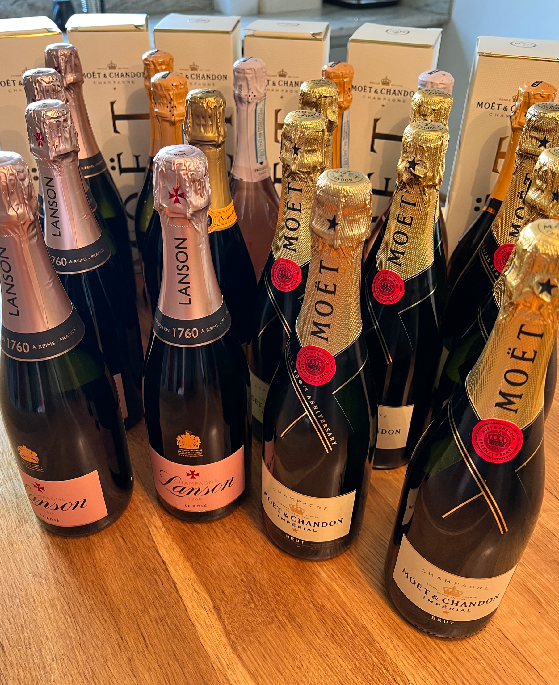 Several bottles of Moët & Chandon champagne on a wooden surface, with boxes in the background.