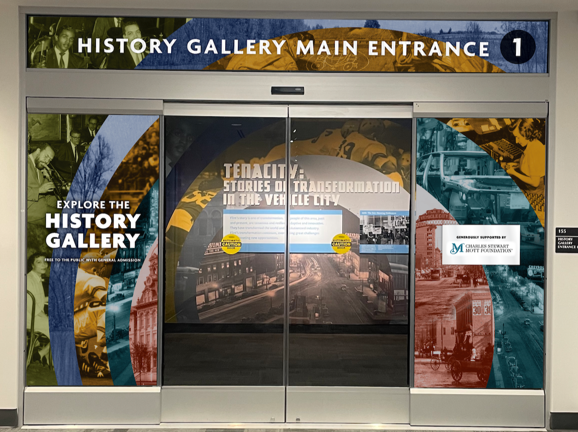 Graphic mockup of glass doors leading into the History Gallery with colorful, full size window graphics featuring archival photos in Flint & Genesee County, Michigan. The signage indicates it is the main entrance to the gallery.
