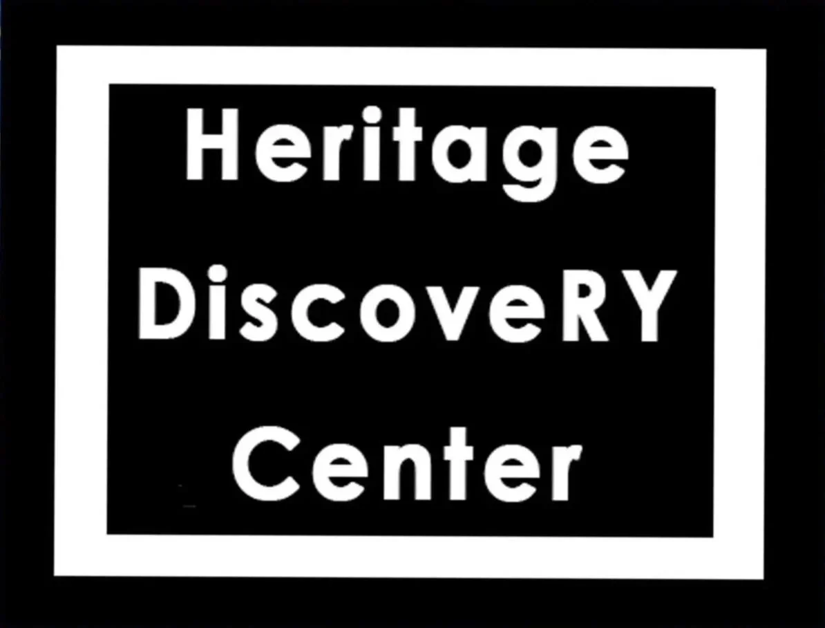 Sign that reads 'Heritage Discovery Center' in white text on a black background with a white border.