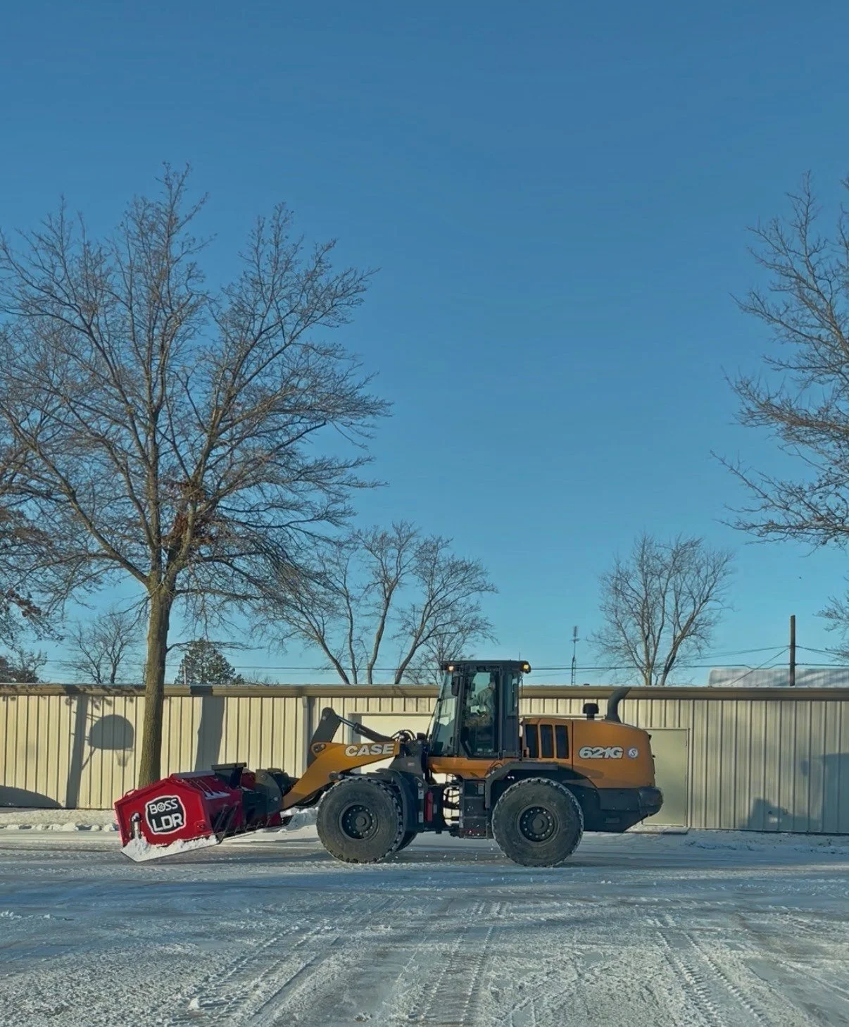 A CASE snowplow with a Boss LDR snowblower attachment clearing snow from a snow-covered road.