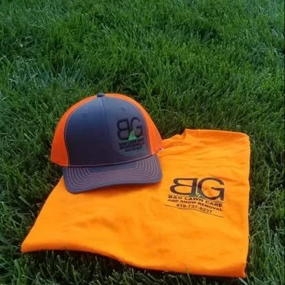 A baseball cap placed on an orange cloth on grass.