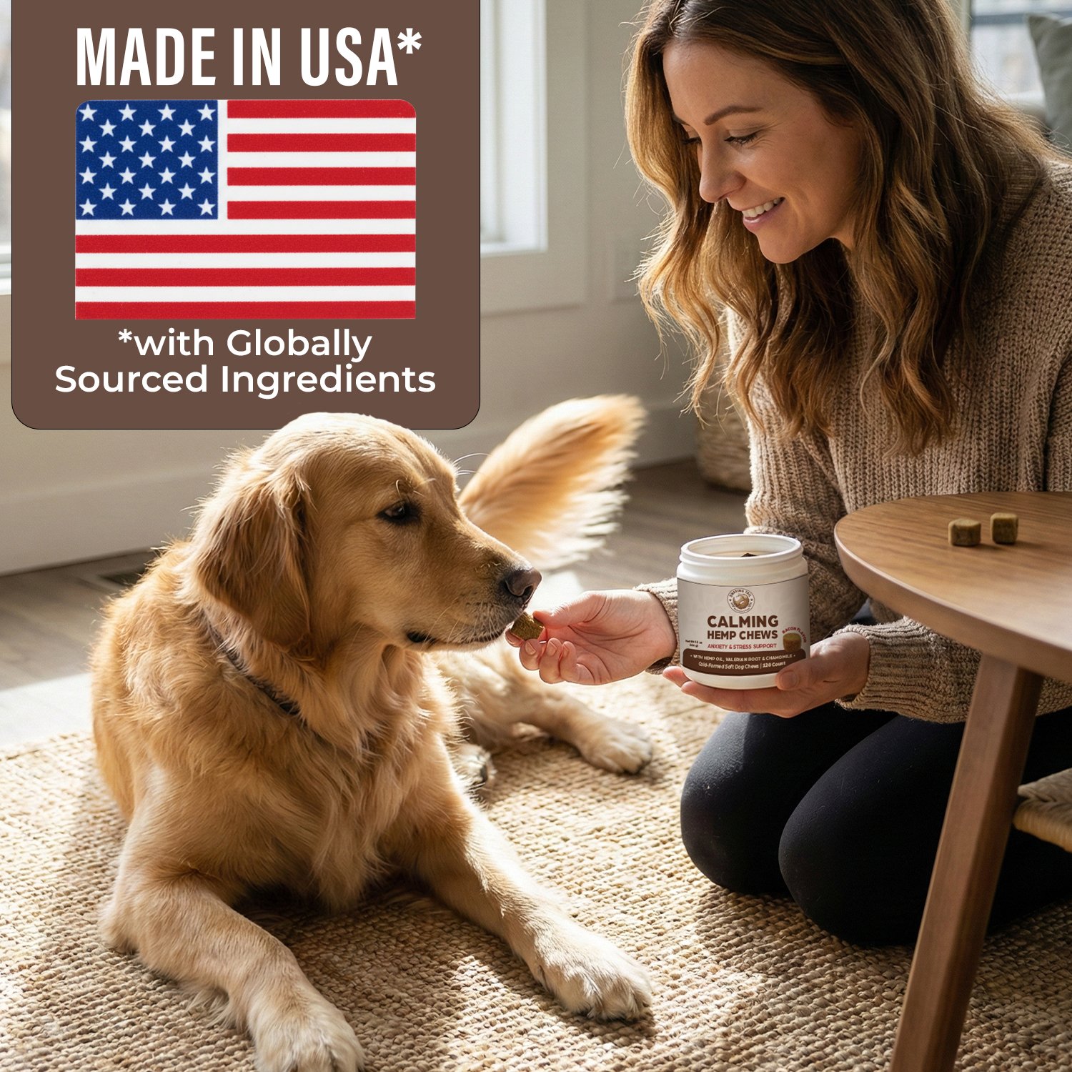 A woman giving a treat to a golden retriever dog inside a home, with a label on the top left indicating the product is made in the USA with globally sourced ingredients, and a container of calming hemp chews in her hand.