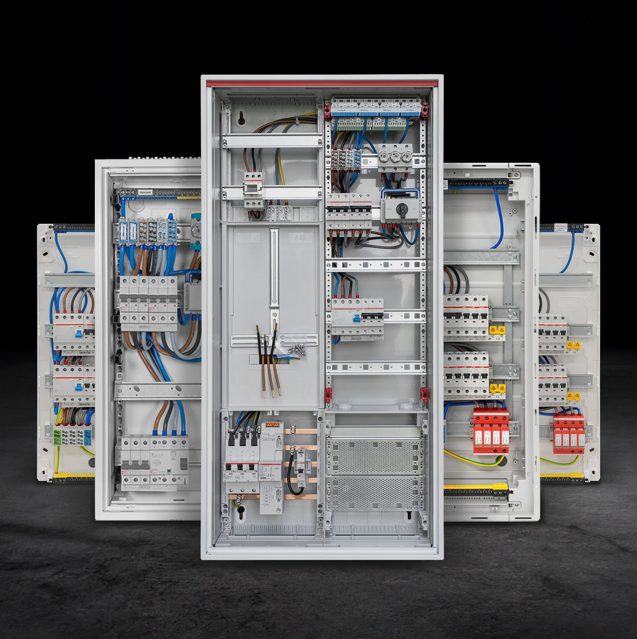 Offener Schaltkasten mit verschiedenen elektrischen Komponenten und Verdrahtungen, vor einem schwarzen Hintergrund.