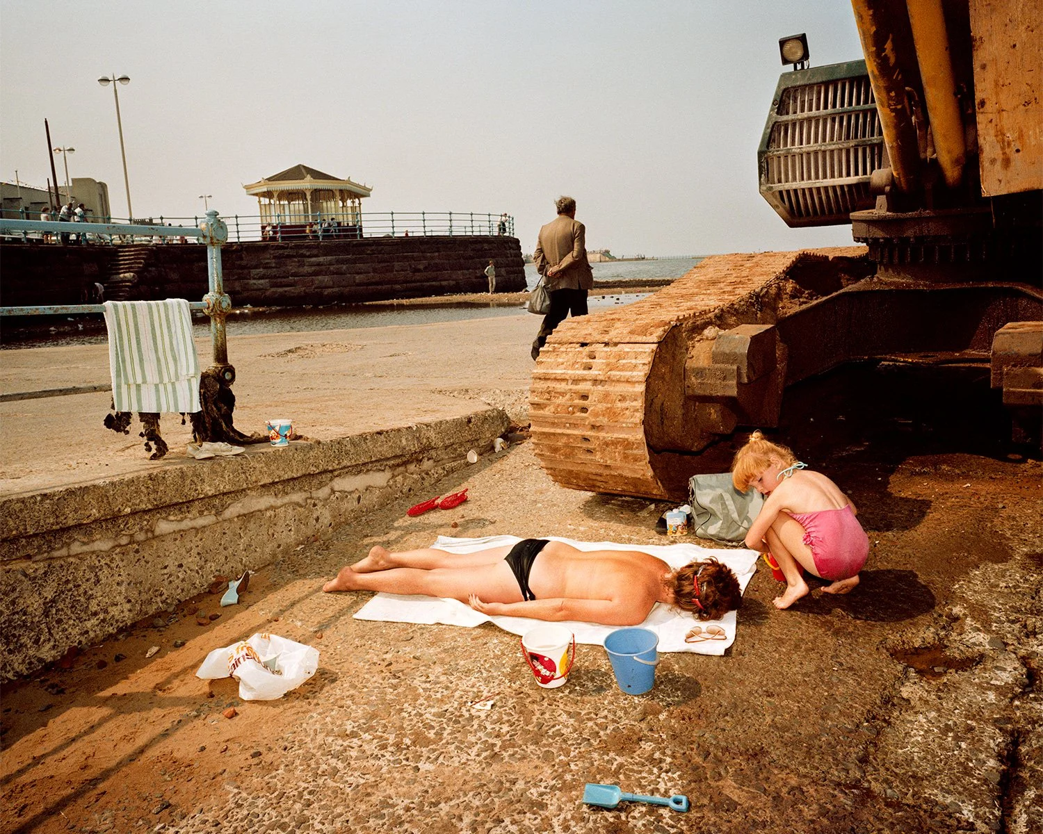 martin parr last resort - מרטין פארר הנופש האחרון 
אישה שוכבת על מגבת ממול דחפור משתזפת