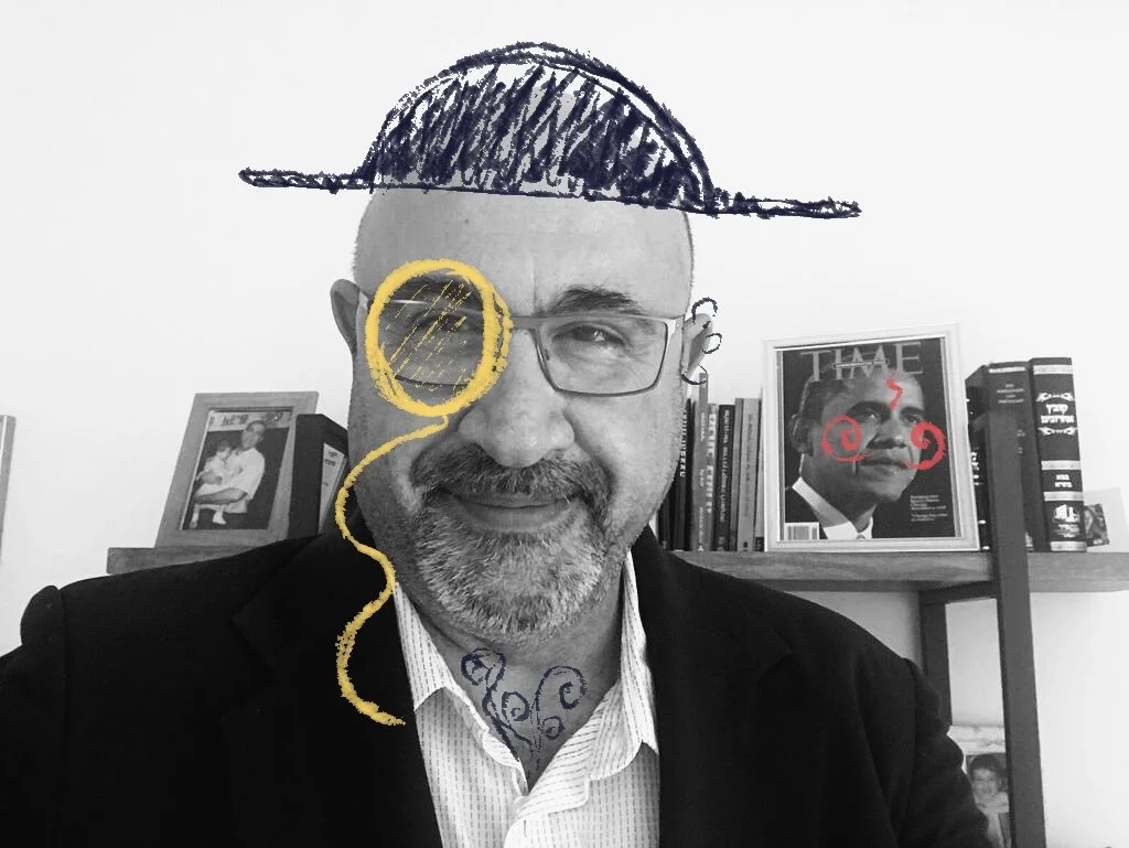 A man with glasses, a beard, and a mustache wearing a white shirt and black blazer. The photo is black and white with colorful hand-drawn elements added: a blue hat, a monocle, and swirly decorations on his face and neck. In the background, there are framed pictures and a bookshelf with books and a magazine.