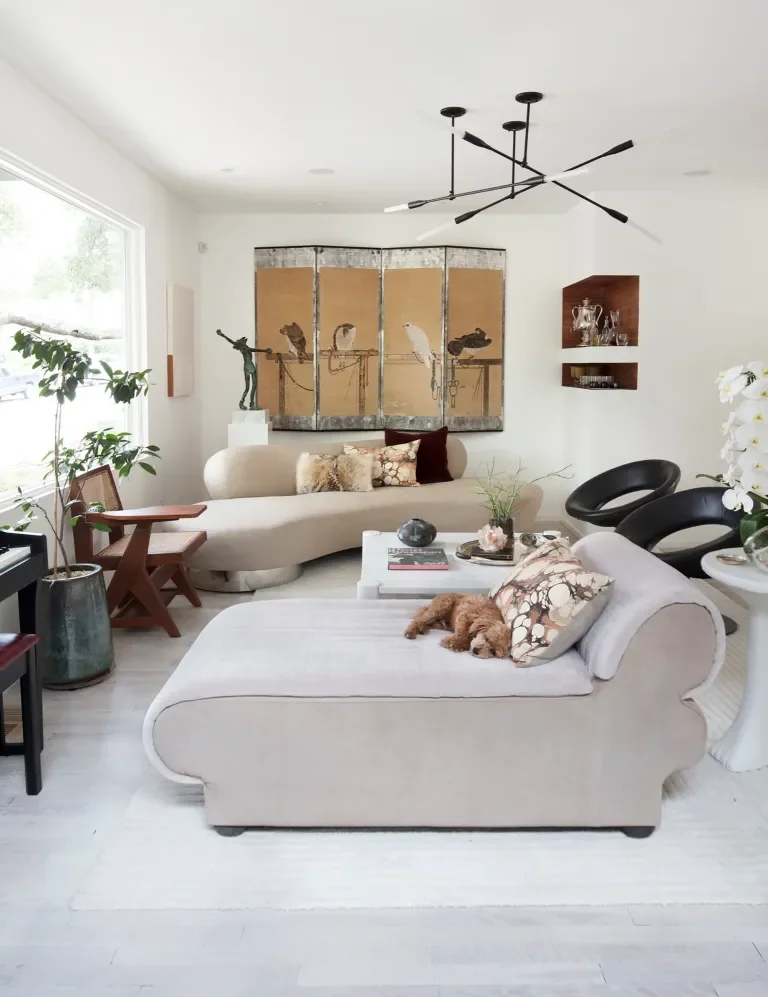 A study in softness and structure, the living space balances sculptural furnishings with curated art and natural light. Clean lines and organic textures create an atmosphere that feels composed yet effortless — a room designed for both quiet mornings