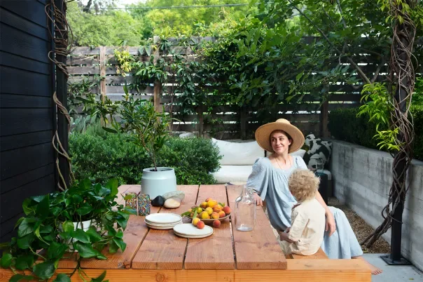 Framed by climbing greenery and warm timber, the outdoor dining area is designed as an extension of the home. Natural materials and layered planting create privacy without enclosure, allowing everyday rituals — morning coffee, shared meals, unhurried