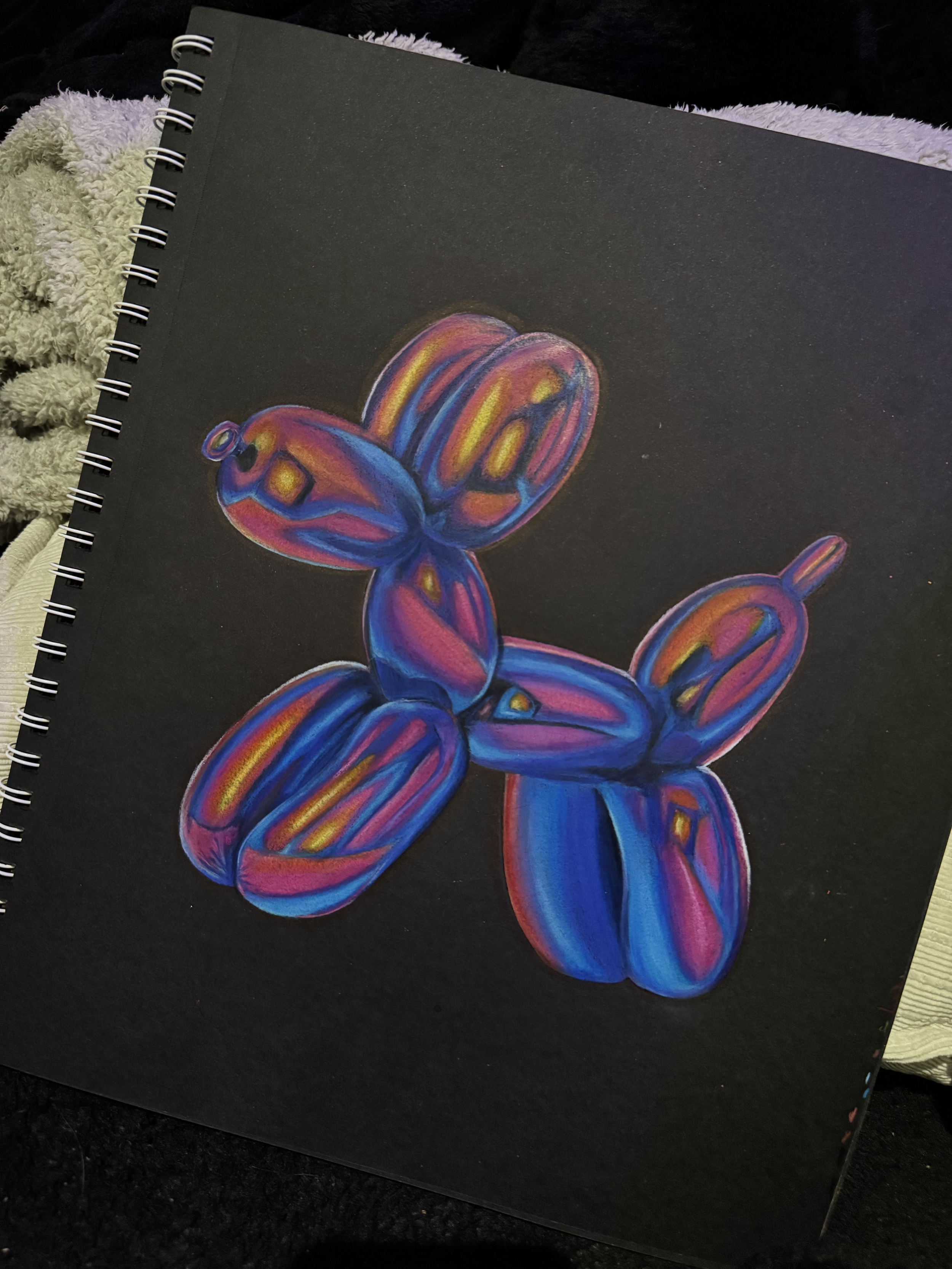 Colorful balloon dog sculpture drawing on black paper with neon-like hues of blue, purple, pink, yellow, and orange.