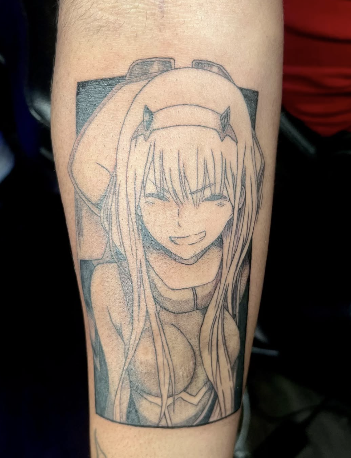 Tattoo of an anime girl with long hair, wearing a headband with animal ears, smiling with eyes closed, on a person's arm.