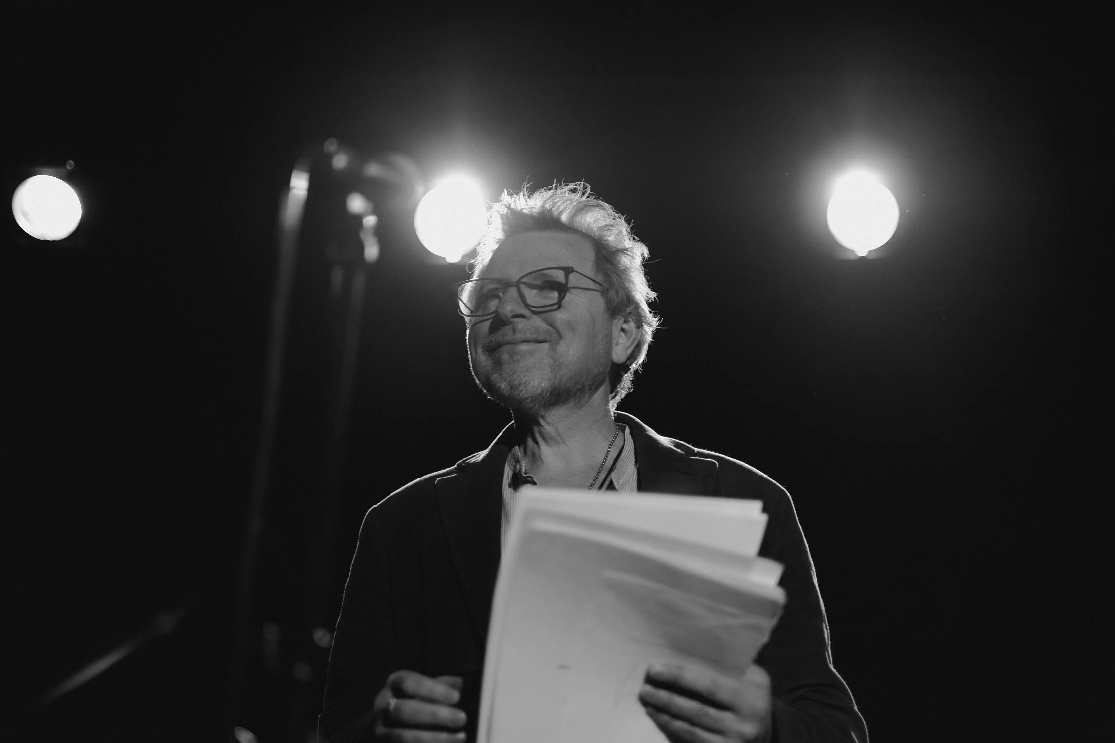 Sandy Kilpatrick speaking on stage with lights behind