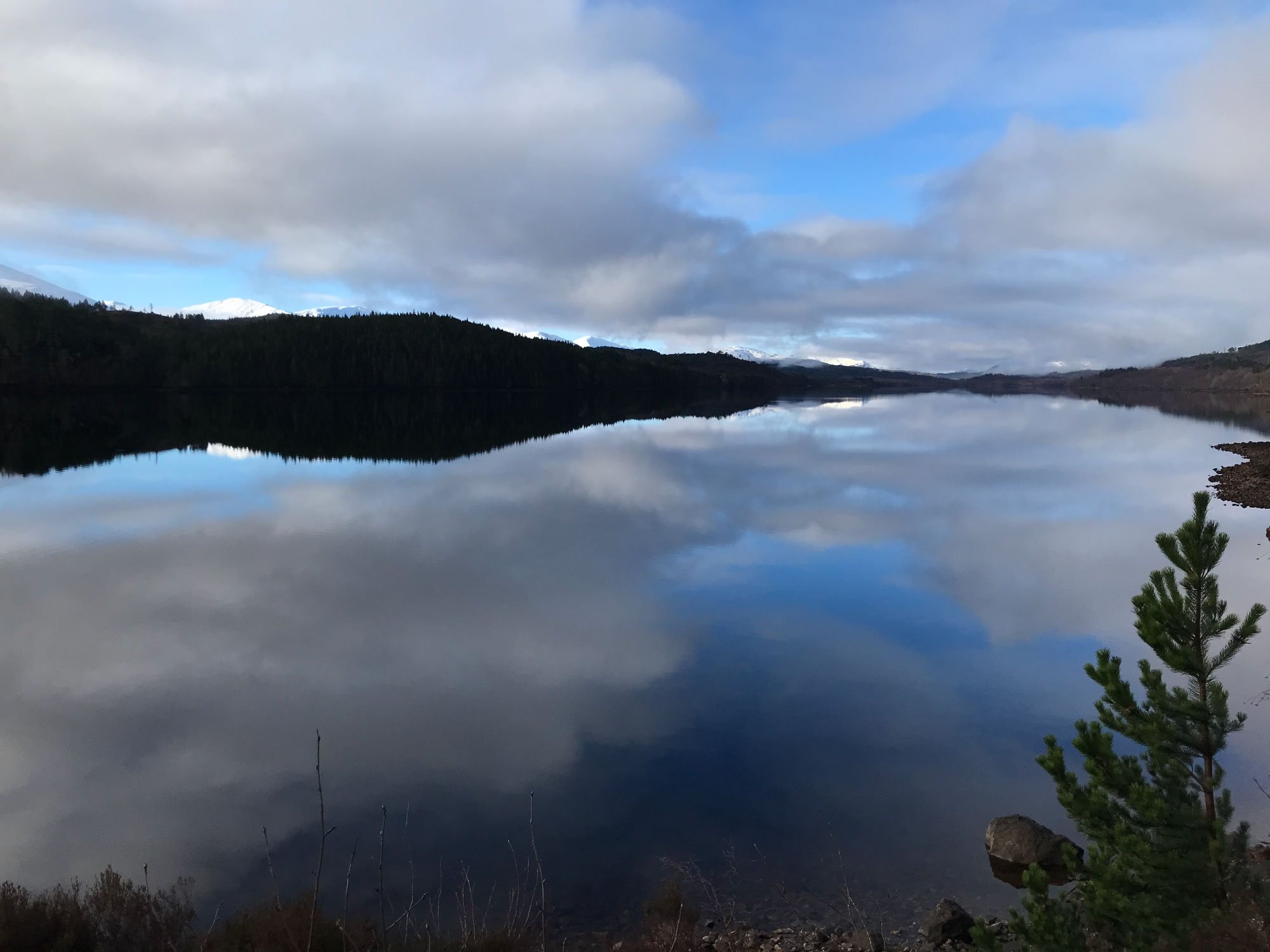 Calm Scottish lake with mountain reflections