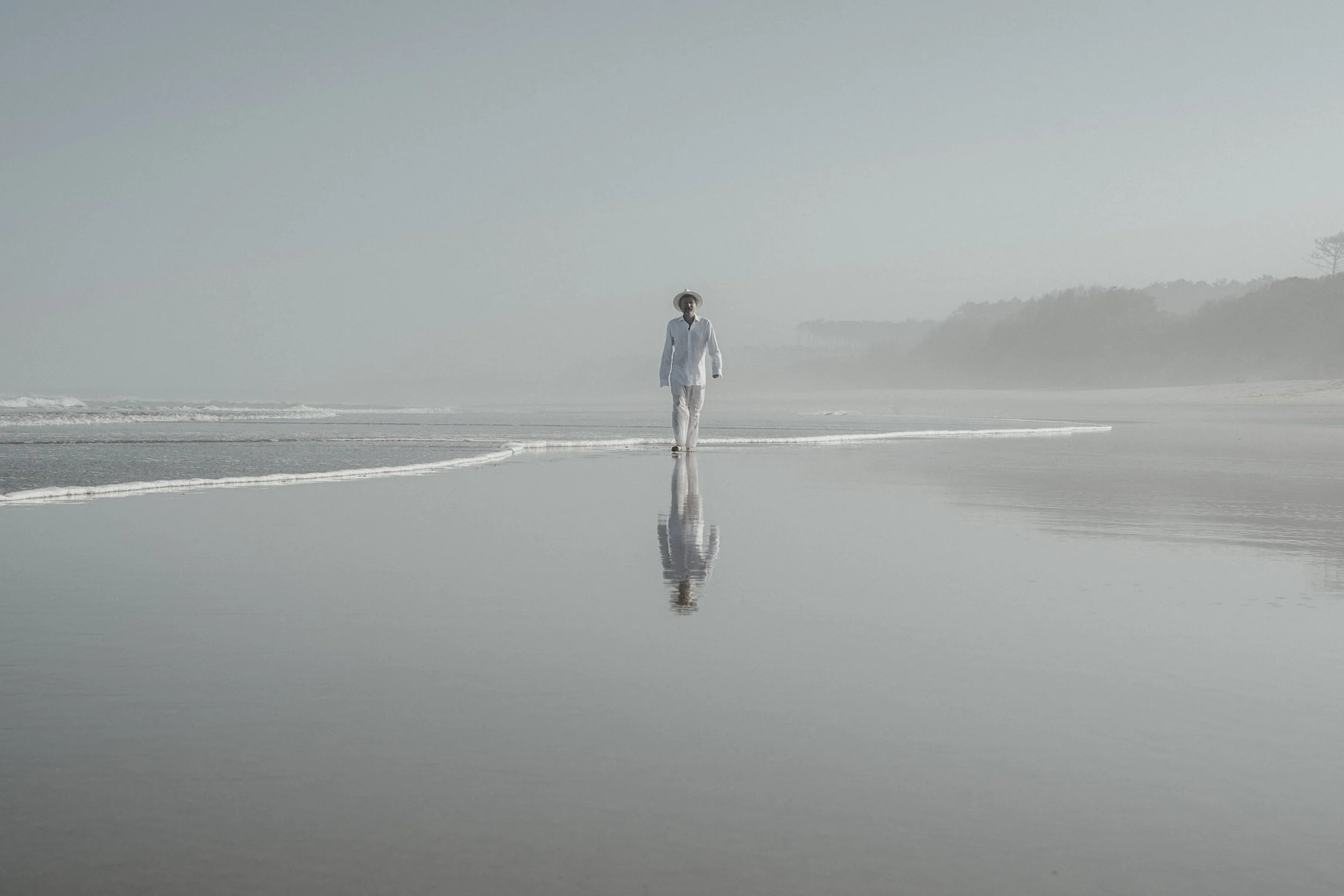 Sandy Kilpatrick walking along reflective shoreline