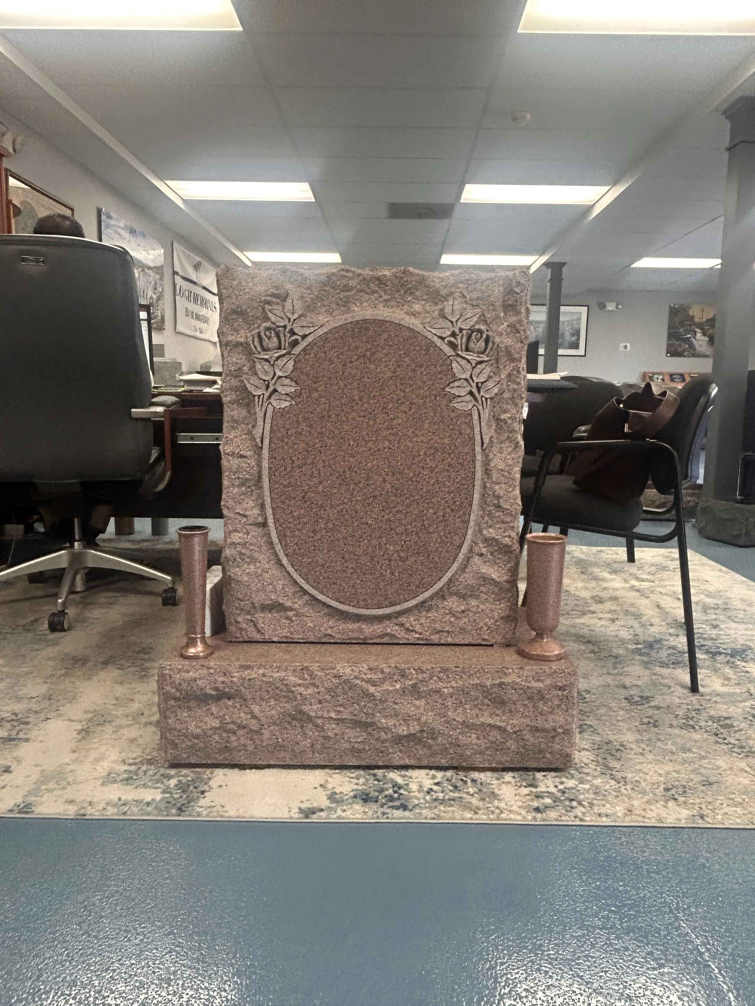 A stone monument with carved roses and an oval area in the center