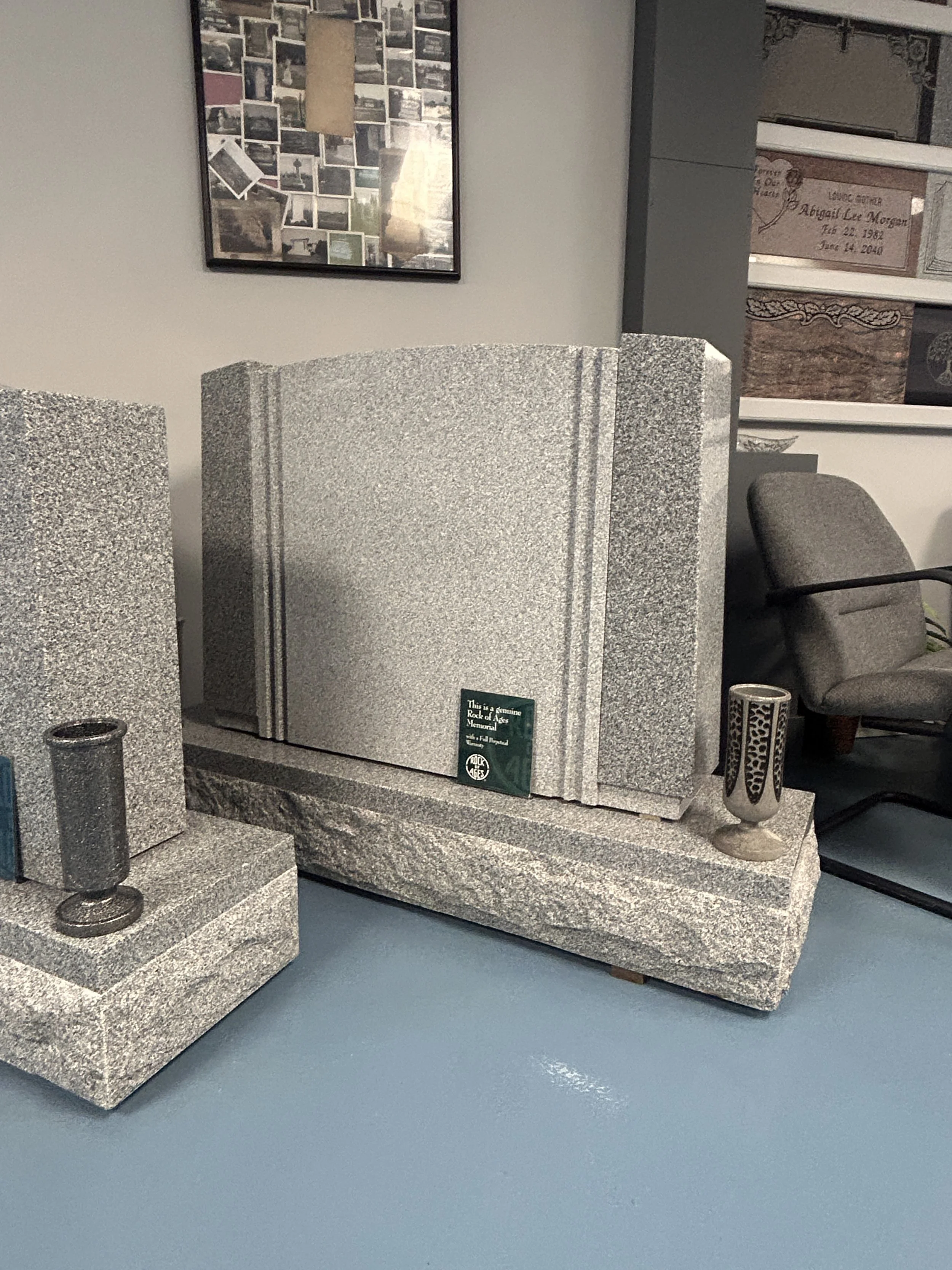 Gravestone display with a large granite monument, two smaller granite markers