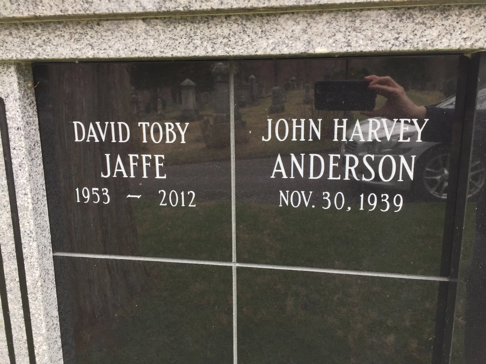 A memorial plaque engraved with names and dates, including David Toby Jaffe and John Harvey Anderson