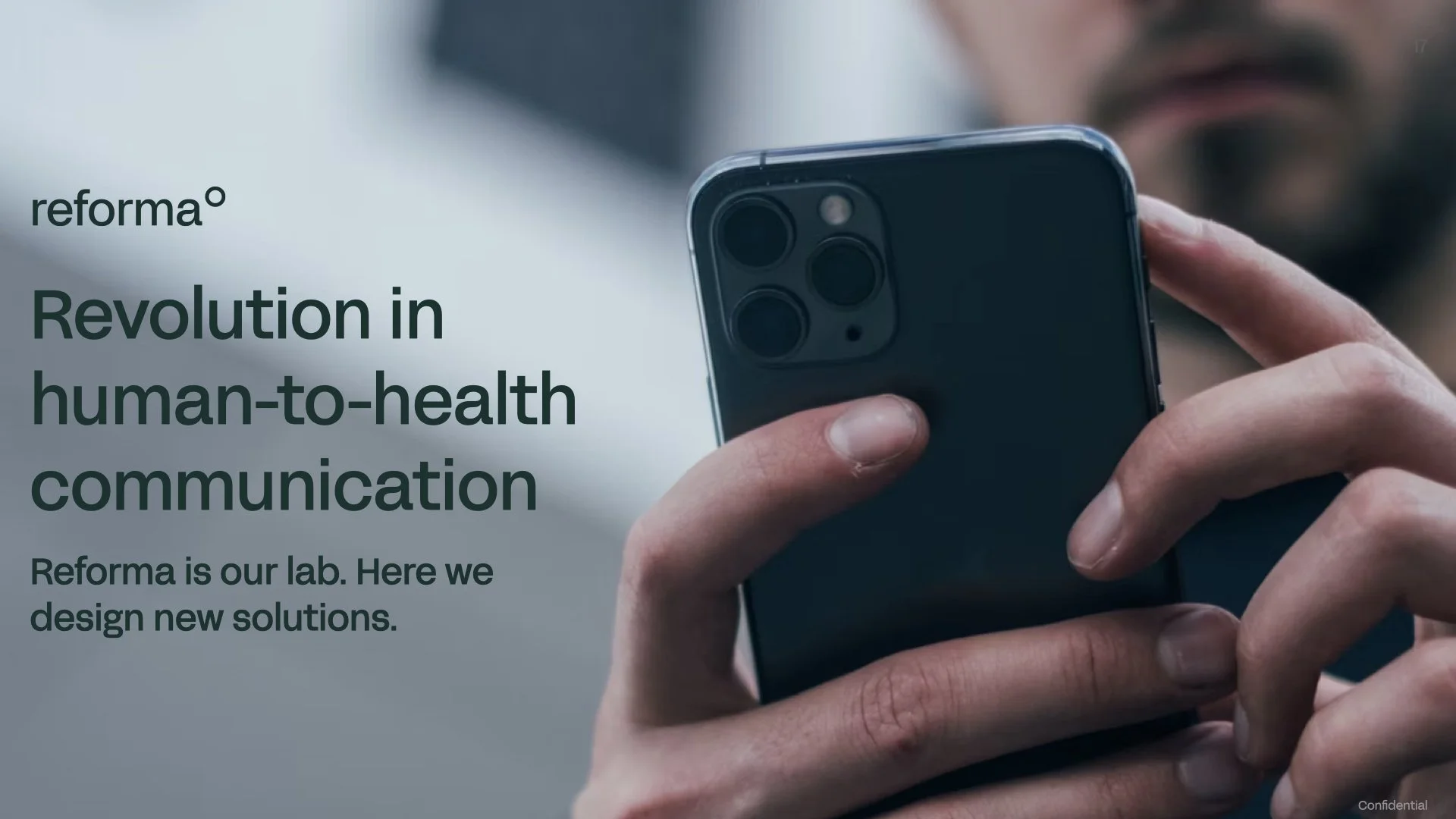 A person holding a smartphone with a focus on the back of the phone showing a camera setup. The background has a blurred and cool-toned appearance.