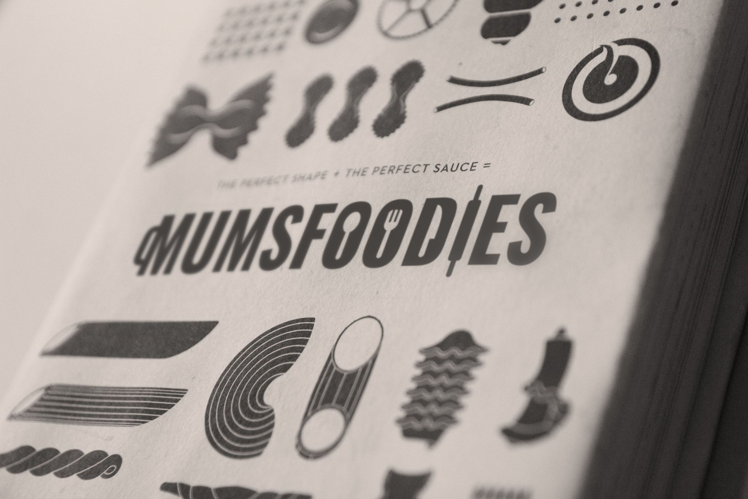 Close-up of a page featuring various food icons, the phrase 'The perfect shape + the perfect sauce = MUMSFODIES', and a collection of stylized food images.