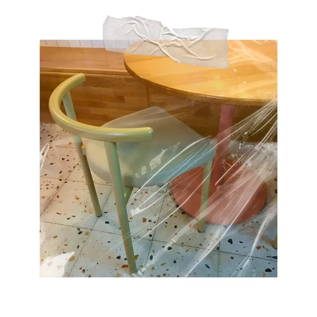 A modern table and chair on a terrazzo floor.