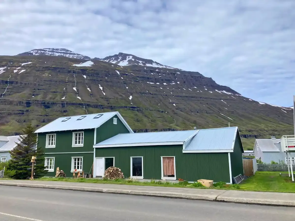 iceland seydisfjordur green house by mountains.webp
