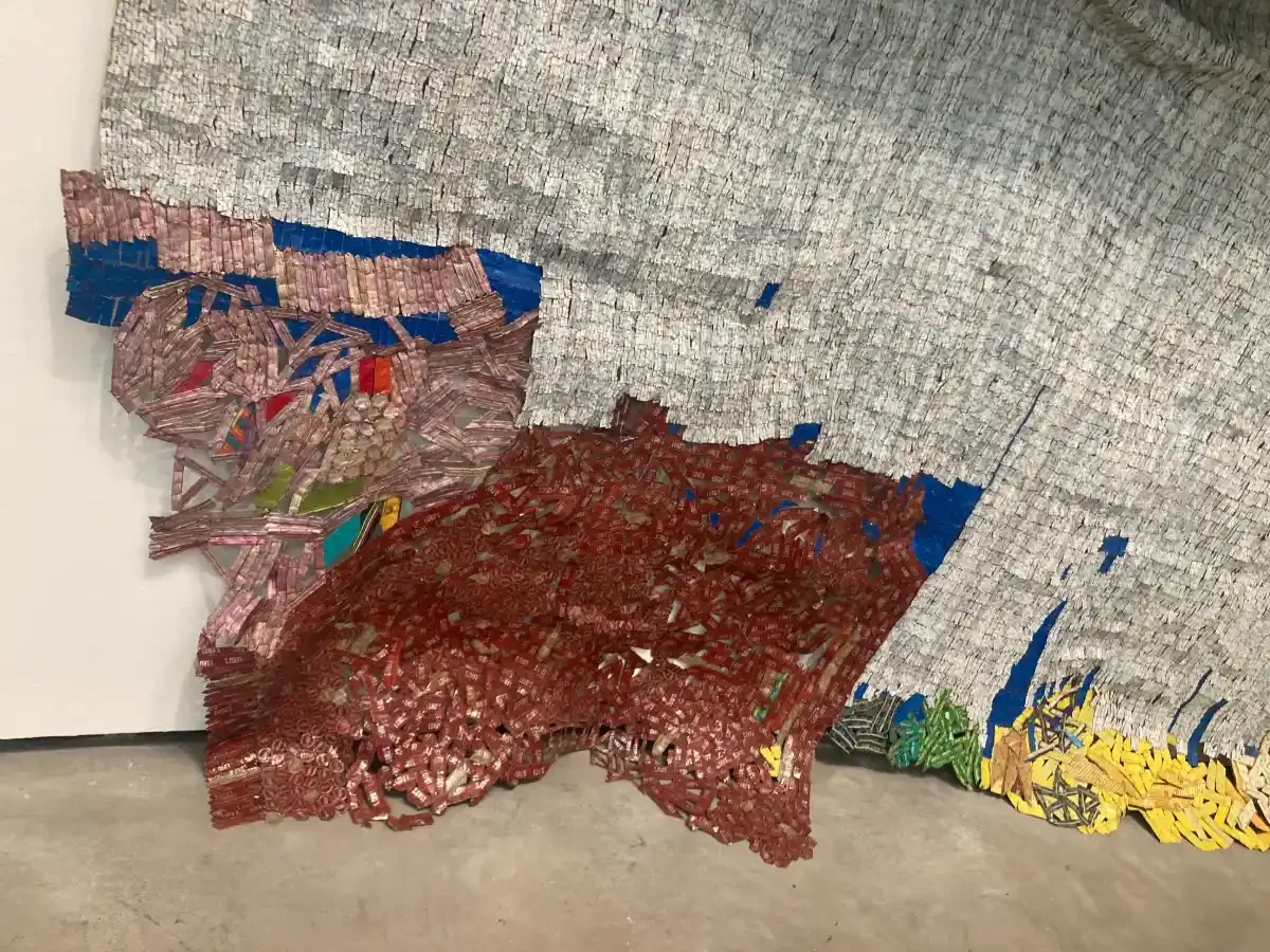 Art in the Guggenheim by El Anatsui, made from discarded liquor bottle caps. Its title 'Rising Sea' serves as a stark metaphor for climate change and the vulnerability of nature and civilisation.