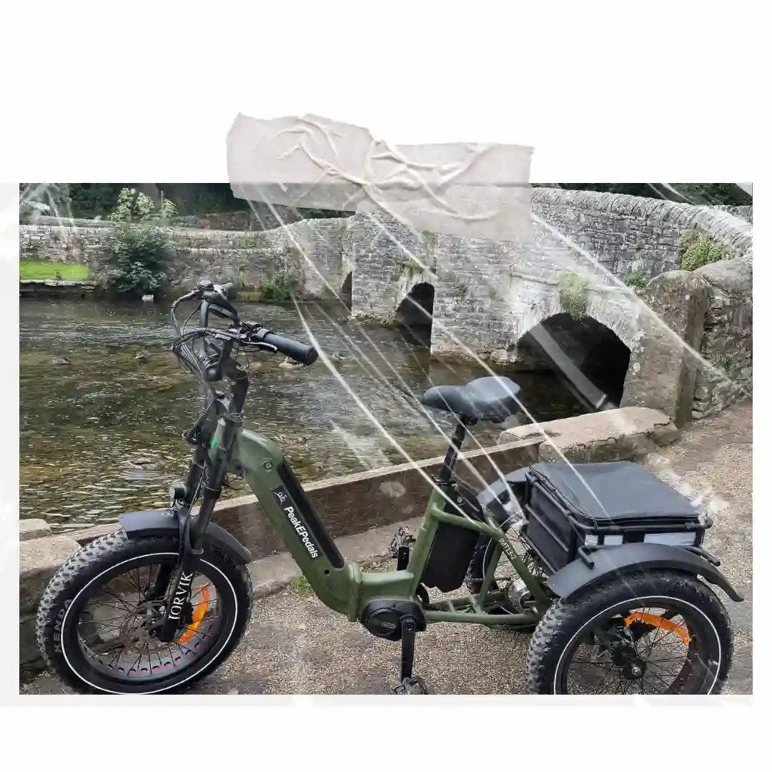 An ebike sits in front of a river with a stoney wall.