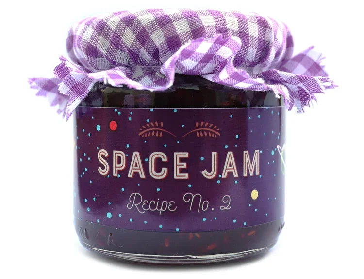 A jar of space jam flavored jam with a purple checkered cloth cover and a label that says 'Space Jam Recipe No. 2'.