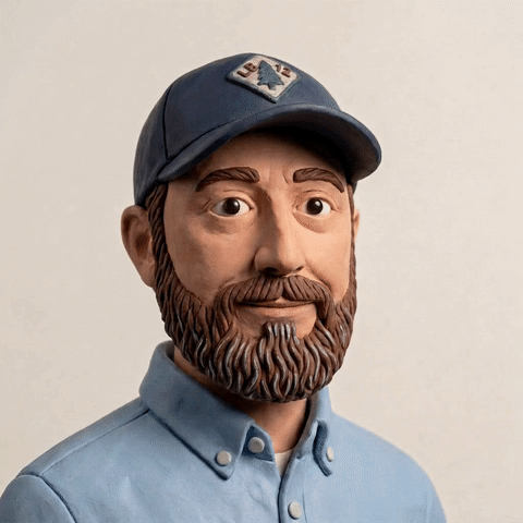 A man with a beard wearing a blue baseball cap and blue shirt.