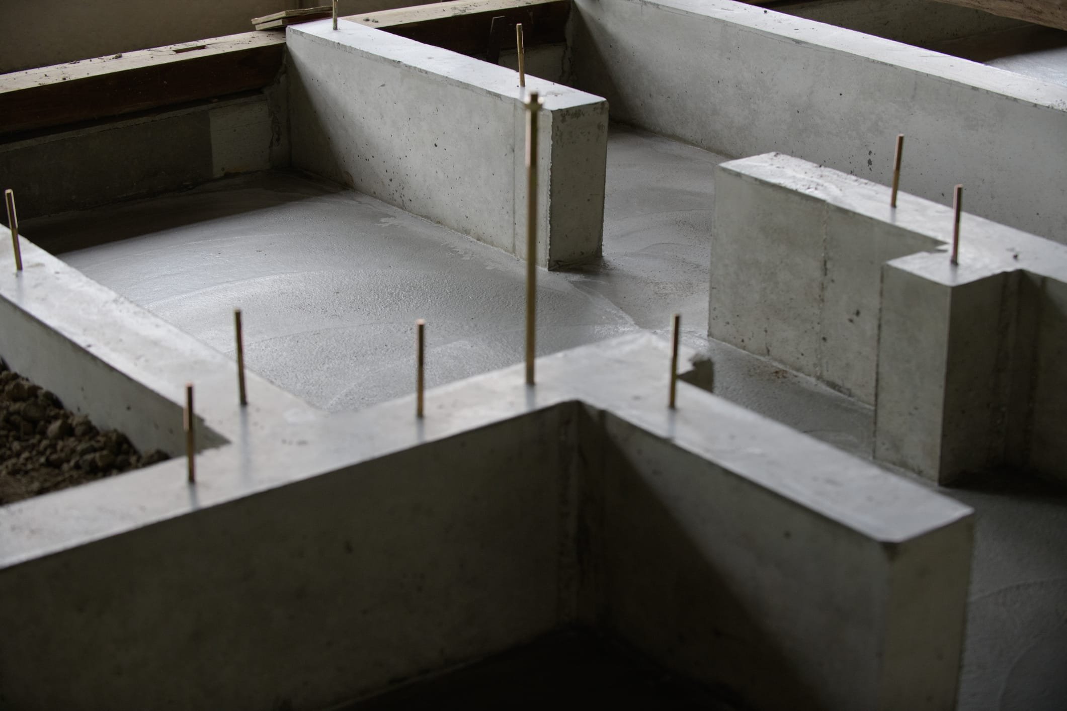 Concrete foundation with metal reinforcement rods for construction.