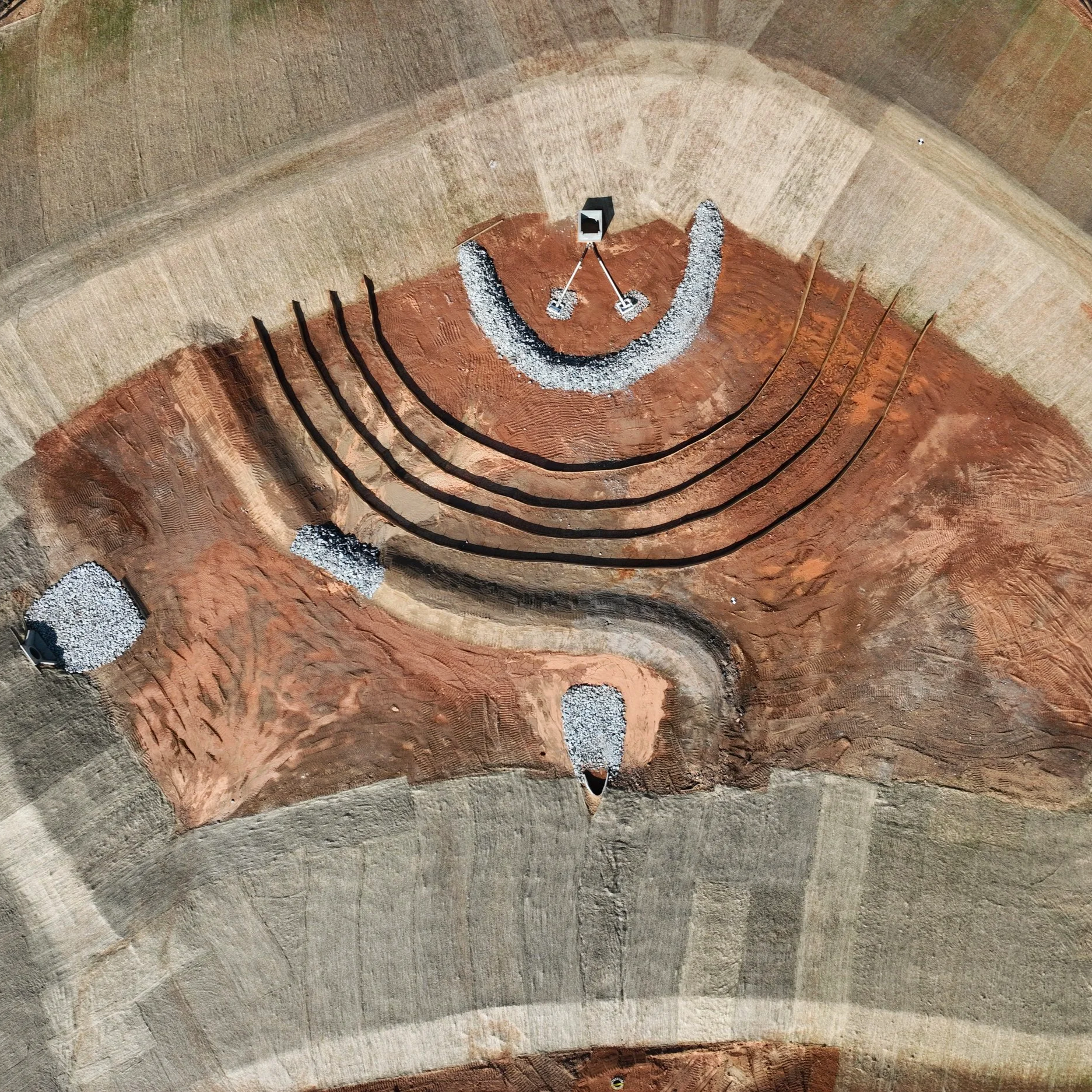 Picture of a storm drainage pond from overhead, clear view of matting and stone to prevent erosion.