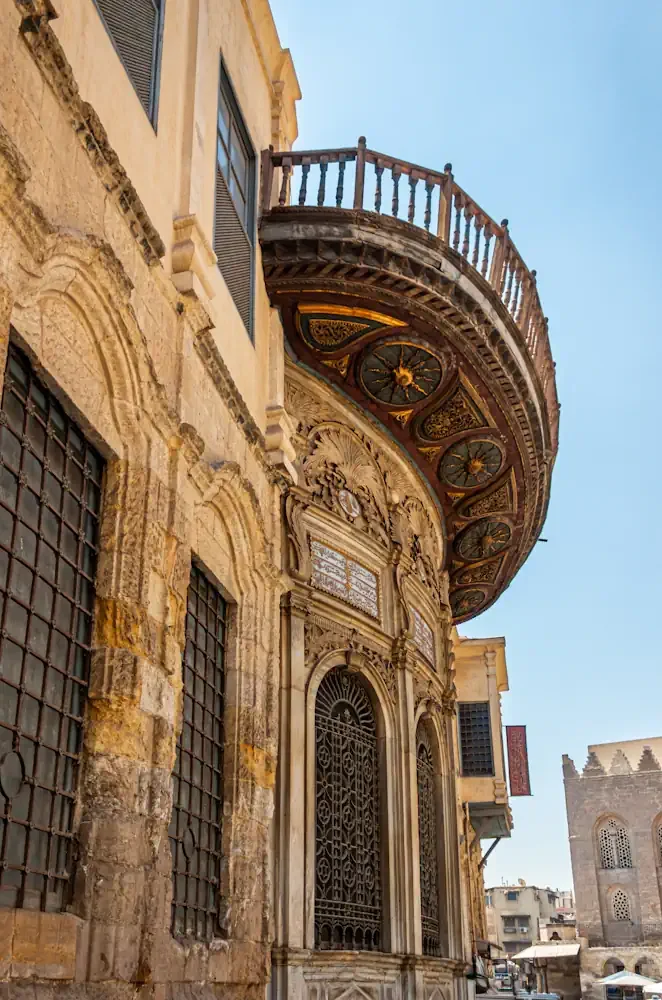 Ornate carved wooden balcony and Ottoman-Mamluk architectural details along El Moez Street in Historic Cairo, Egypt.