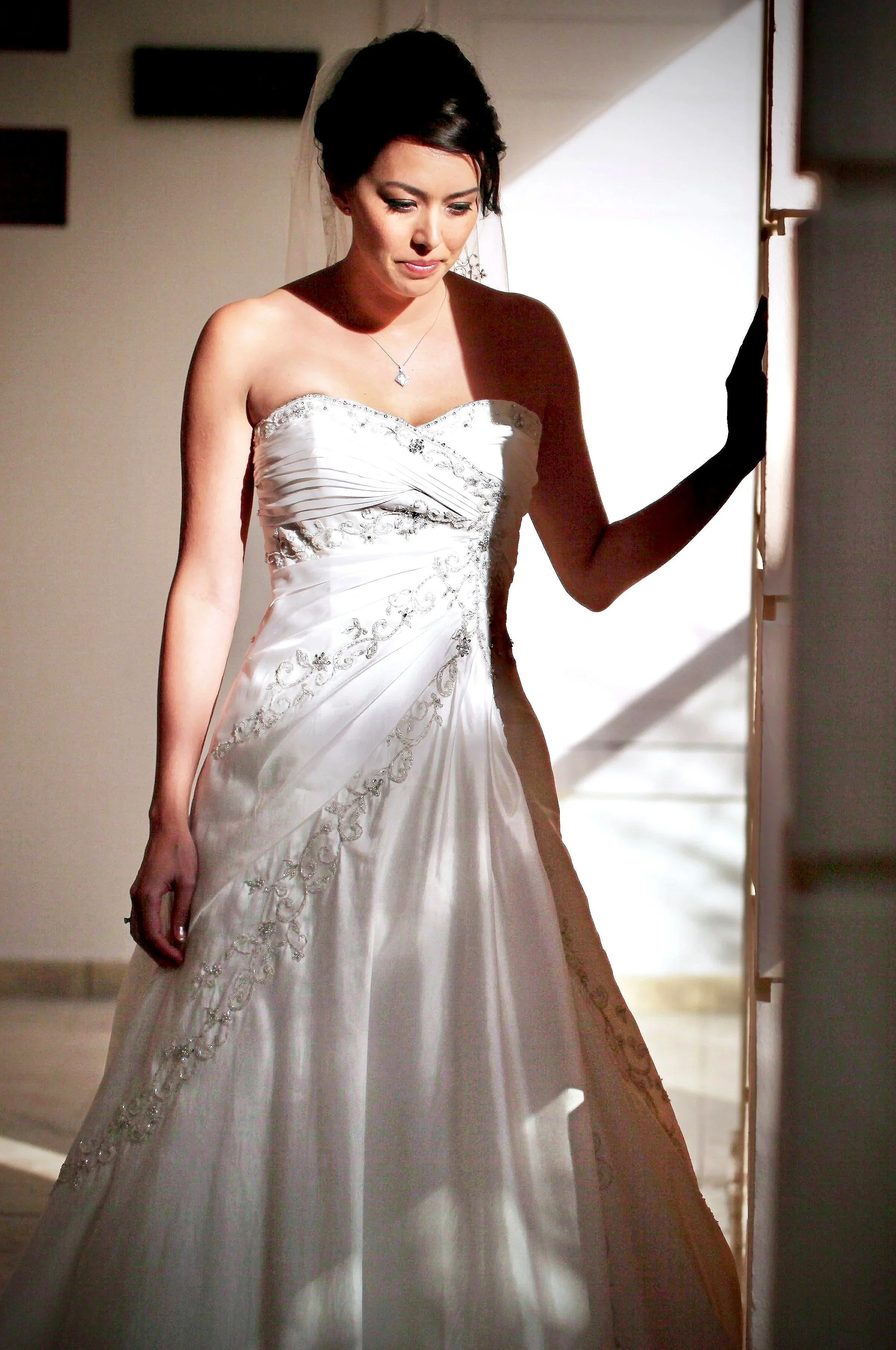 Bride with soft glam wedding makeup by Elisa Flowers, elegant updo hairstyle and strapless gown.