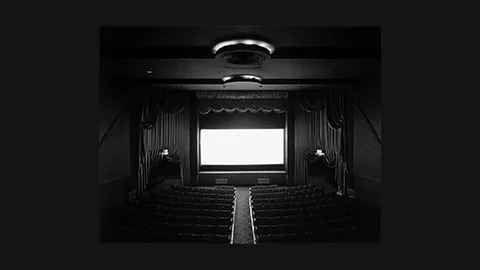 Sugimoto 1977: glowing white cinema screen surrounded by dark theatre interior – full-length film exposure captured as a single image
