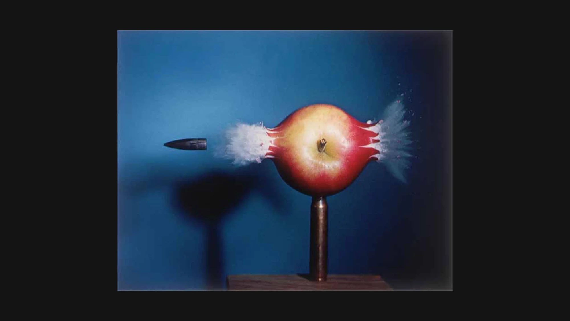 Edgerton 1964: bullet piercing apple mid-flight, frozen at 1/1,000,000 sec – high-speed stroboscopic photography, MIT