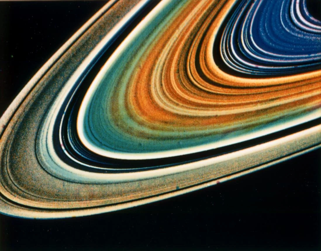 NASA Voyager 1981: enhanced-colour image of Saturn's rings — false-colour processing revealing compositional variations across the ring system.