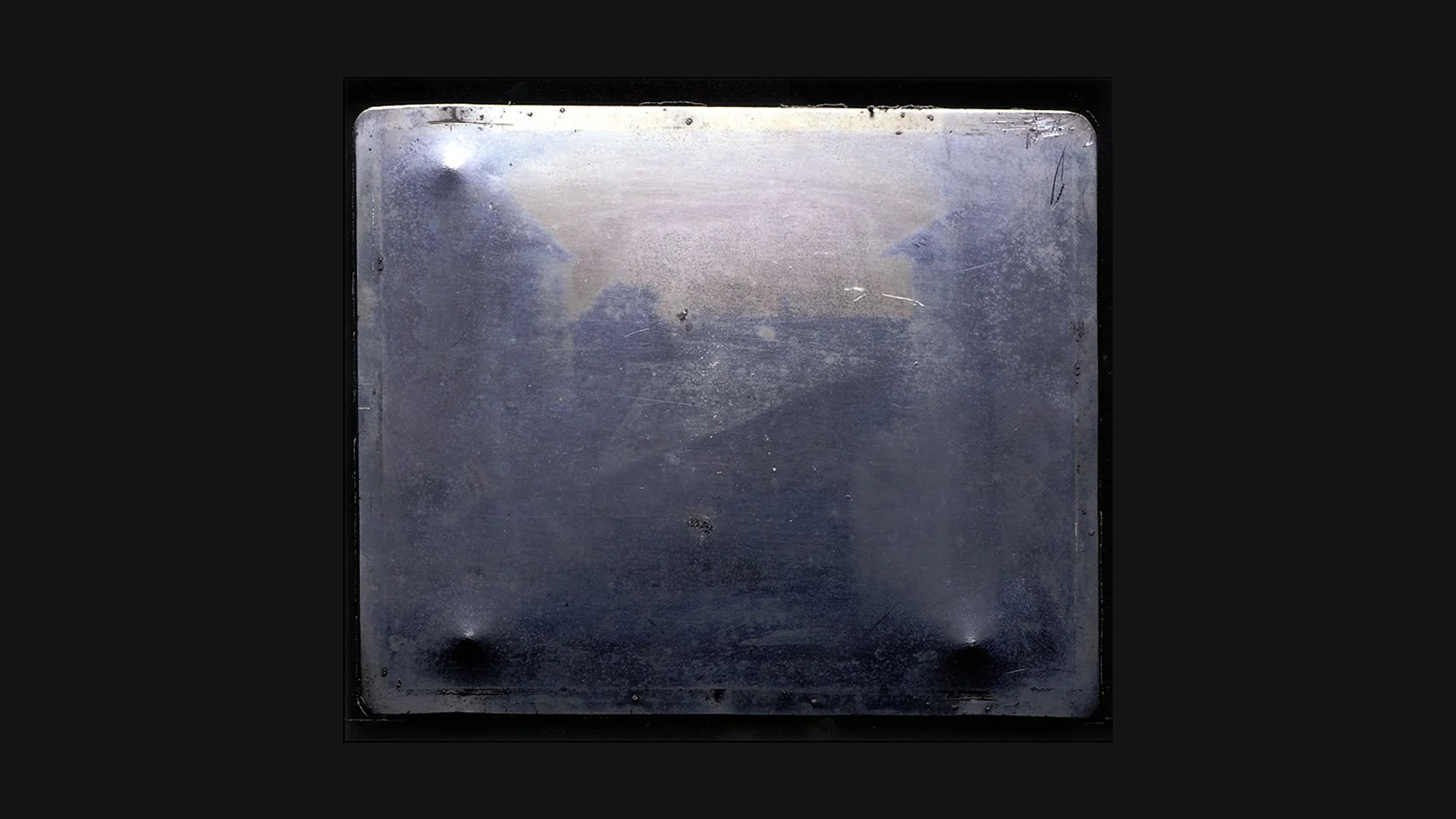 Niépce 1827: blurred rooftop view from upper window, oldest surviving permanent photograph – heliograph on pewter plate