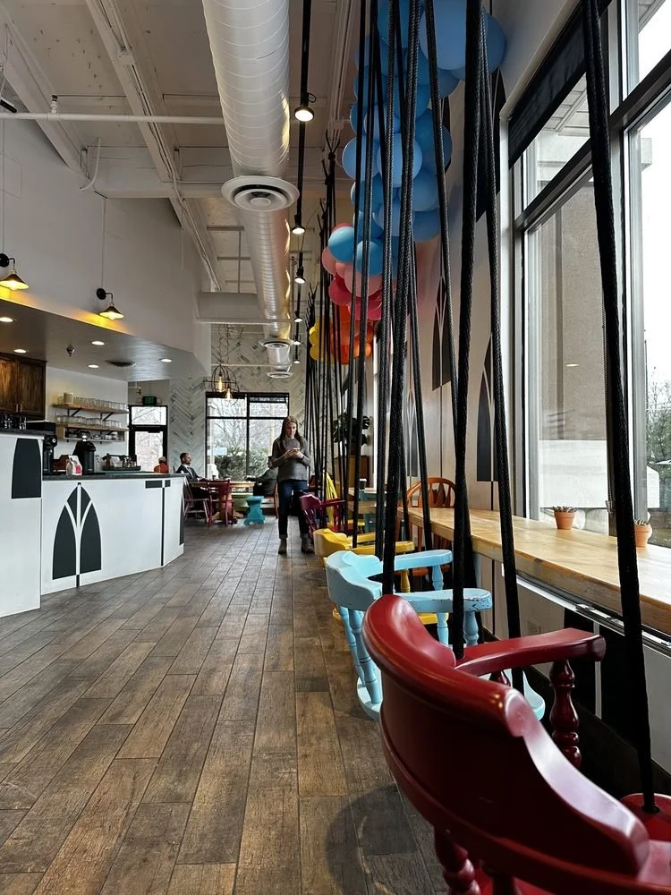 Cafe interior with colorful hanging chairs and balloons