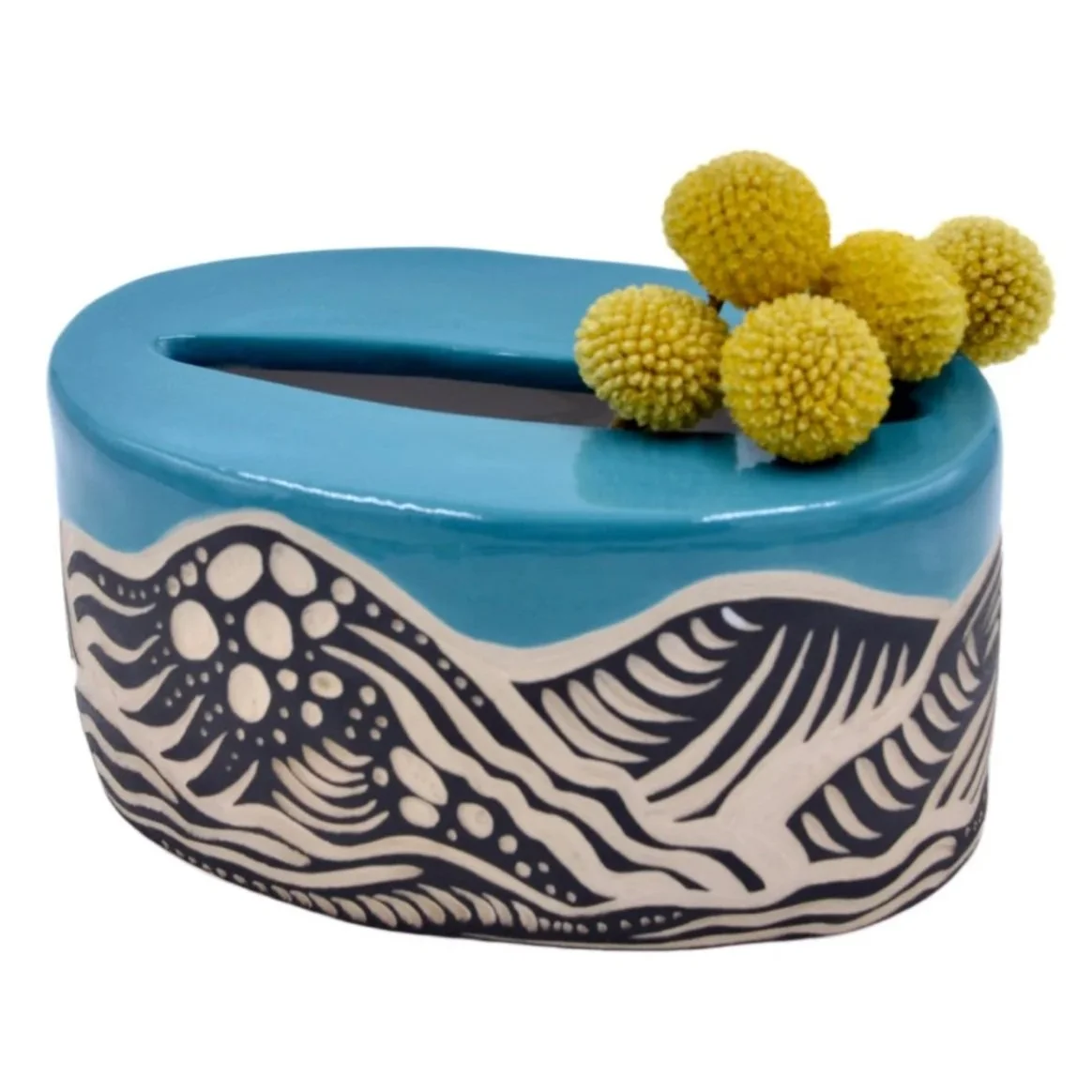 A decorative blue and black patterned tissue box with yellow craspedia flowers on top.