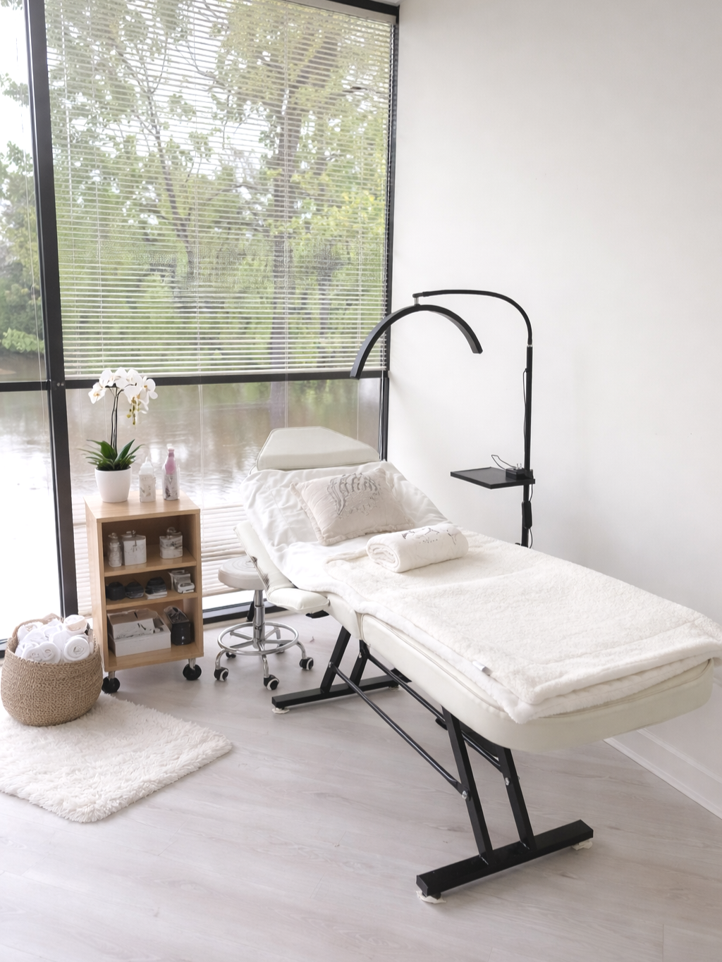 A modern, minimalist massage or treatment room with a white adjustable massage table, 
Castrian Makeup Studio; Emily Gonzalez; Atlanta, Georgia; Bridal Make-Up; Norcross, Spanish Make-Up Artist; esthetician rental