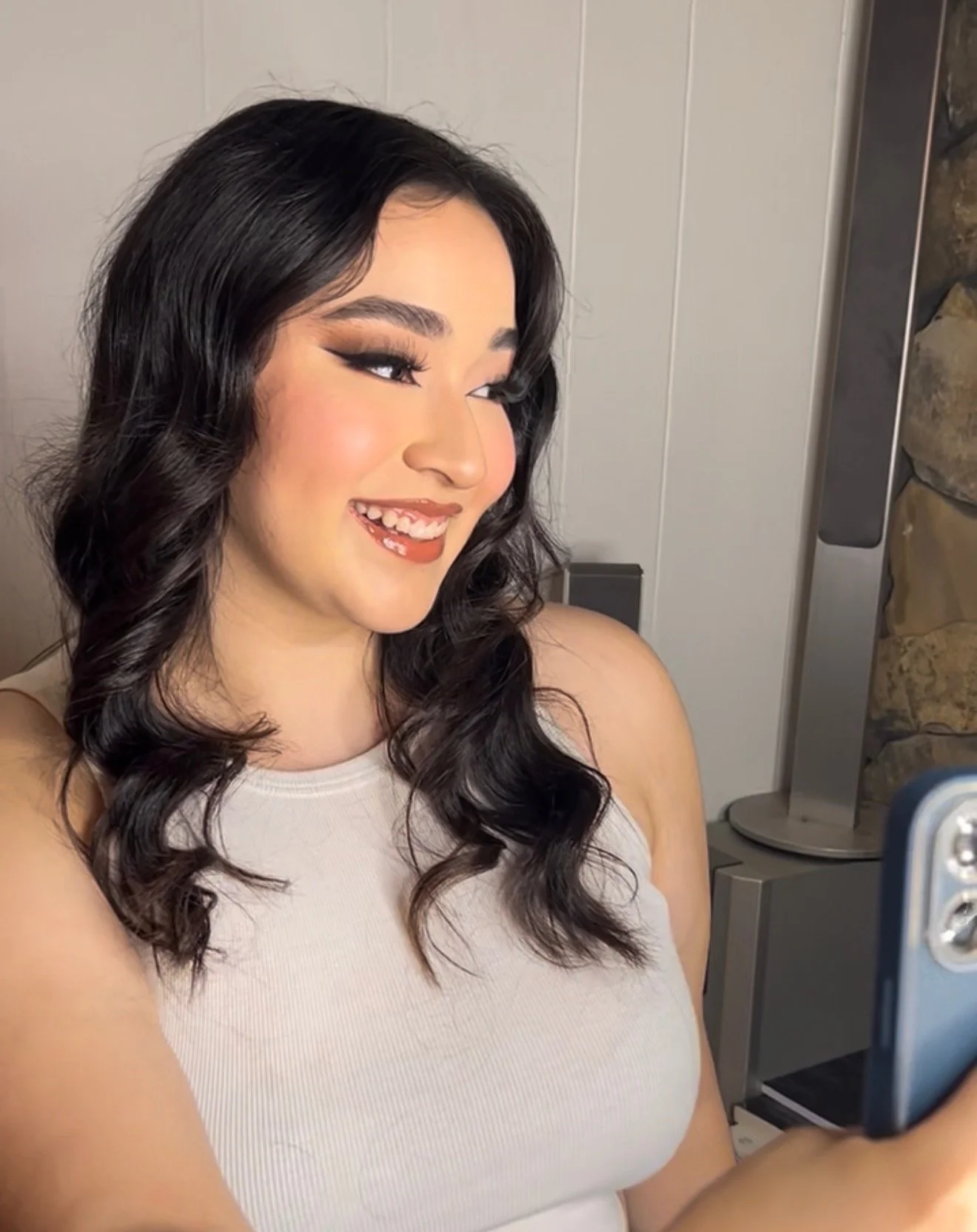 Close-up of a young woman with long black wavy hair, makeup, and a beige tank top, smiling
Castrian Makeup Studio; Emily Gonzalez; Atlanta, Georgia; Bridal Make-Up; Norcross, Spanish Make-Up Artist; teeth whitening