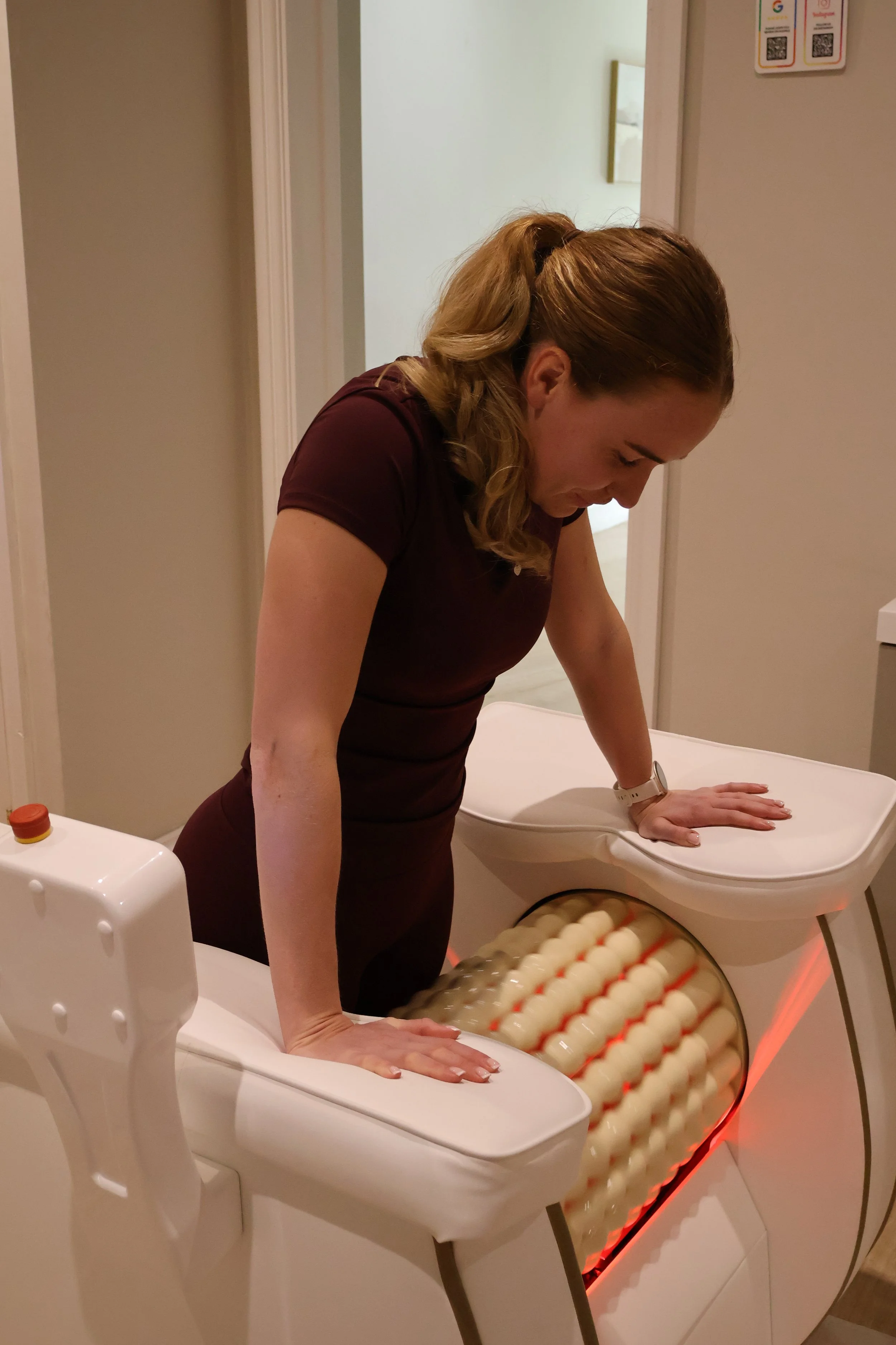 Client using lymphatic roller machine for body treatment in wellness clinic.