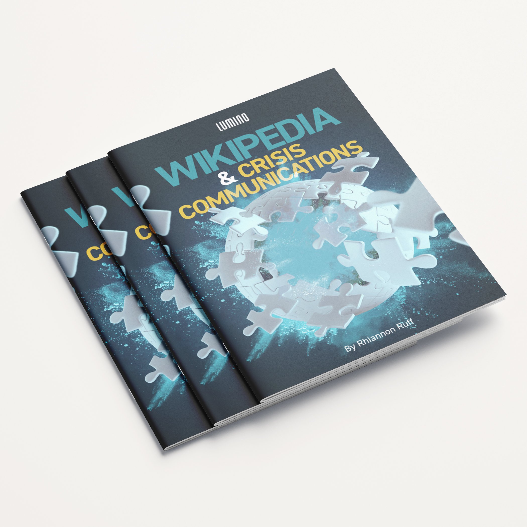Three copies of a book titled 'Wikipedia & Crisis Communications' by Rhiannon Ruff, with a cover design featuring a globe made of puzzle pieces fitting together.
