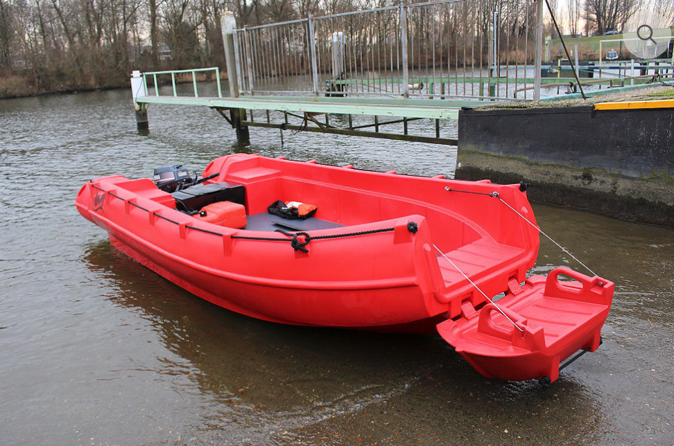 Red Whaly 500R boat tied up beside a dock on a body of water.