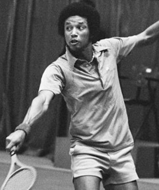 A Black woman playing tennis, preparing to hit a shot with a racquet, wearing a short-sleeved shirt and shorts, in a black-and-white photo.