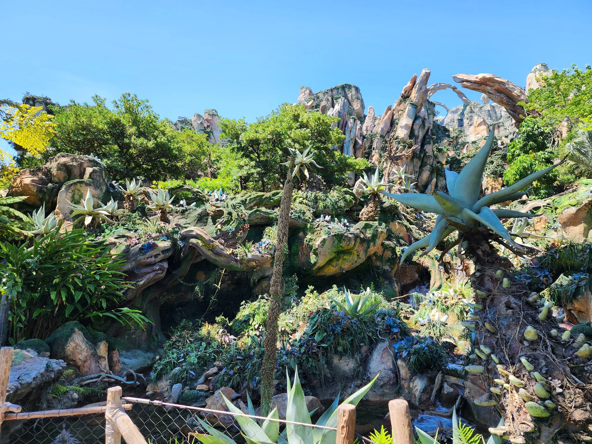 Featured in this image is the soring rockwork mountain that begins at grade and terminates on the roof of the ride building.  Also seen are cantilever rock broken rock shards and one of the rock arches.   