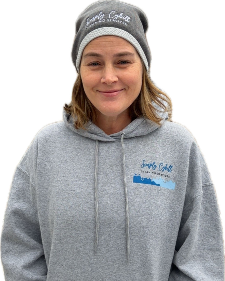 A woman smiling, wearing a gray beanie hat and a gray hoodie with a logo that reads 'Simply Chill Cleaning Services'.