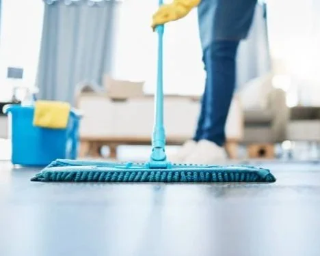 Person mopping the floor in a living room.