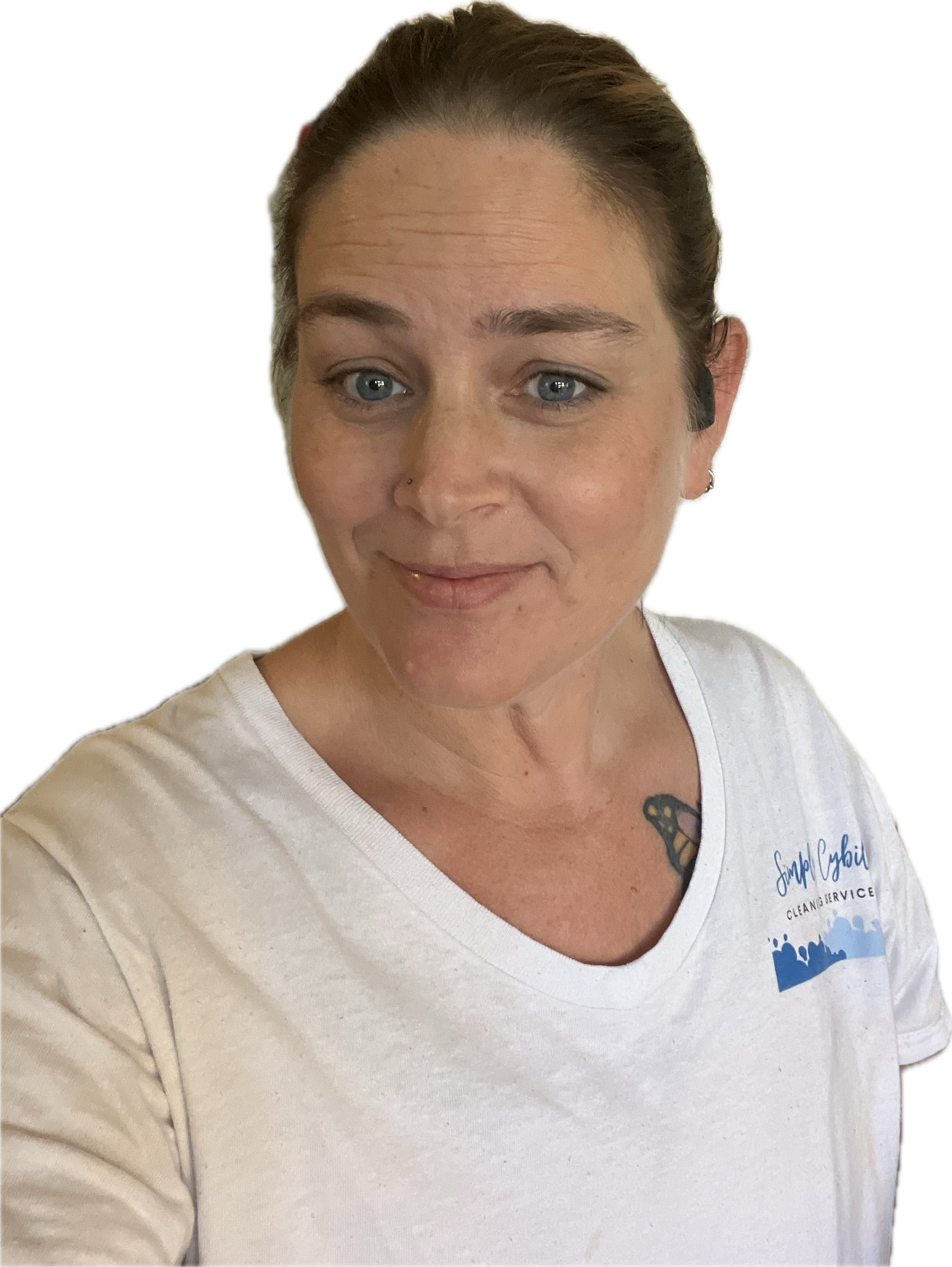 A woman with blue eyes and brown hair pulled back, wearing a white T-shirt with a logo that reads 'Small Cobble Cleaning Service,' is smiling and looking slightly to the left.