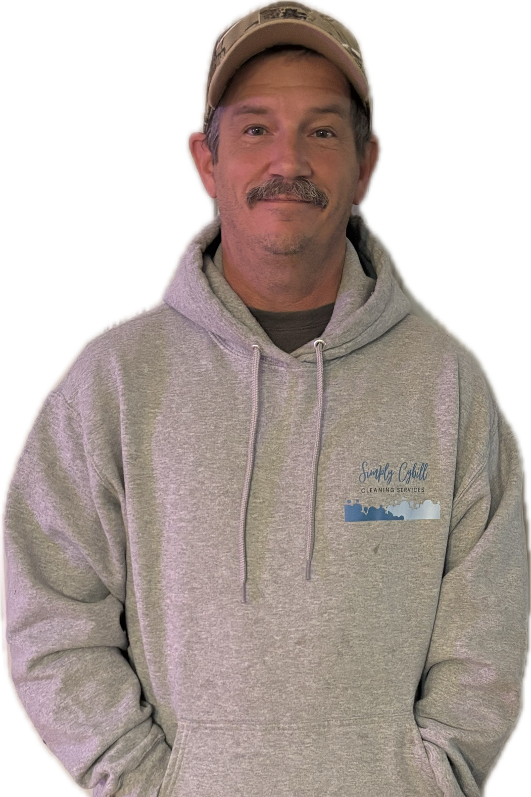 A man in a gray hoodie and baseball cap smiling at the camera, with text on his hoodie that reads 'Simply Cubbill Cleaning Services' along with a logo of a city skyline.
