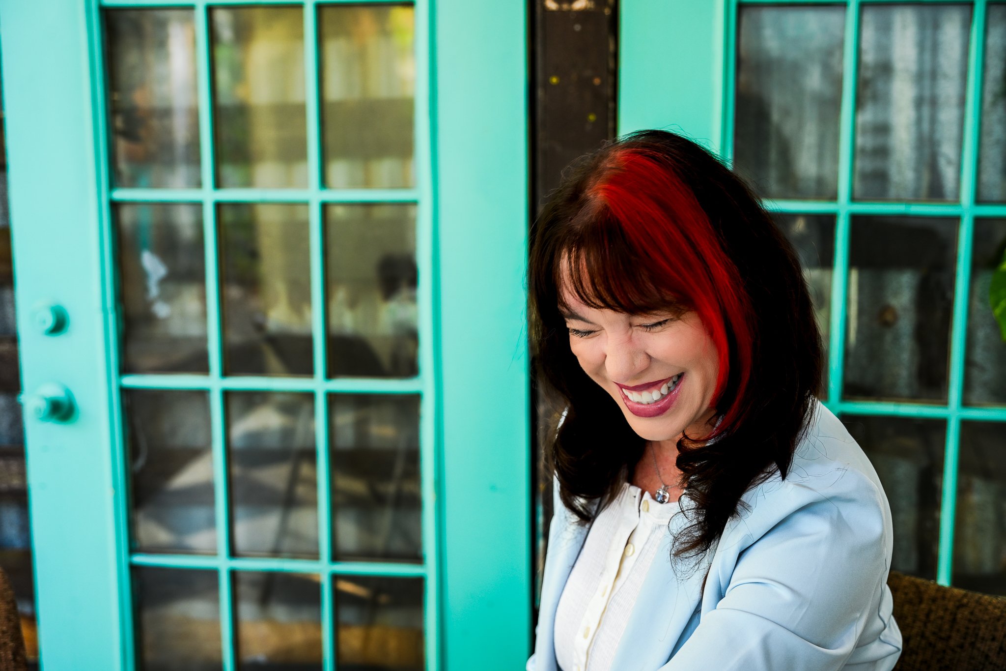 Professional woman during lifestyle headshot session at local coffee shop, laughing, in Largo, FL