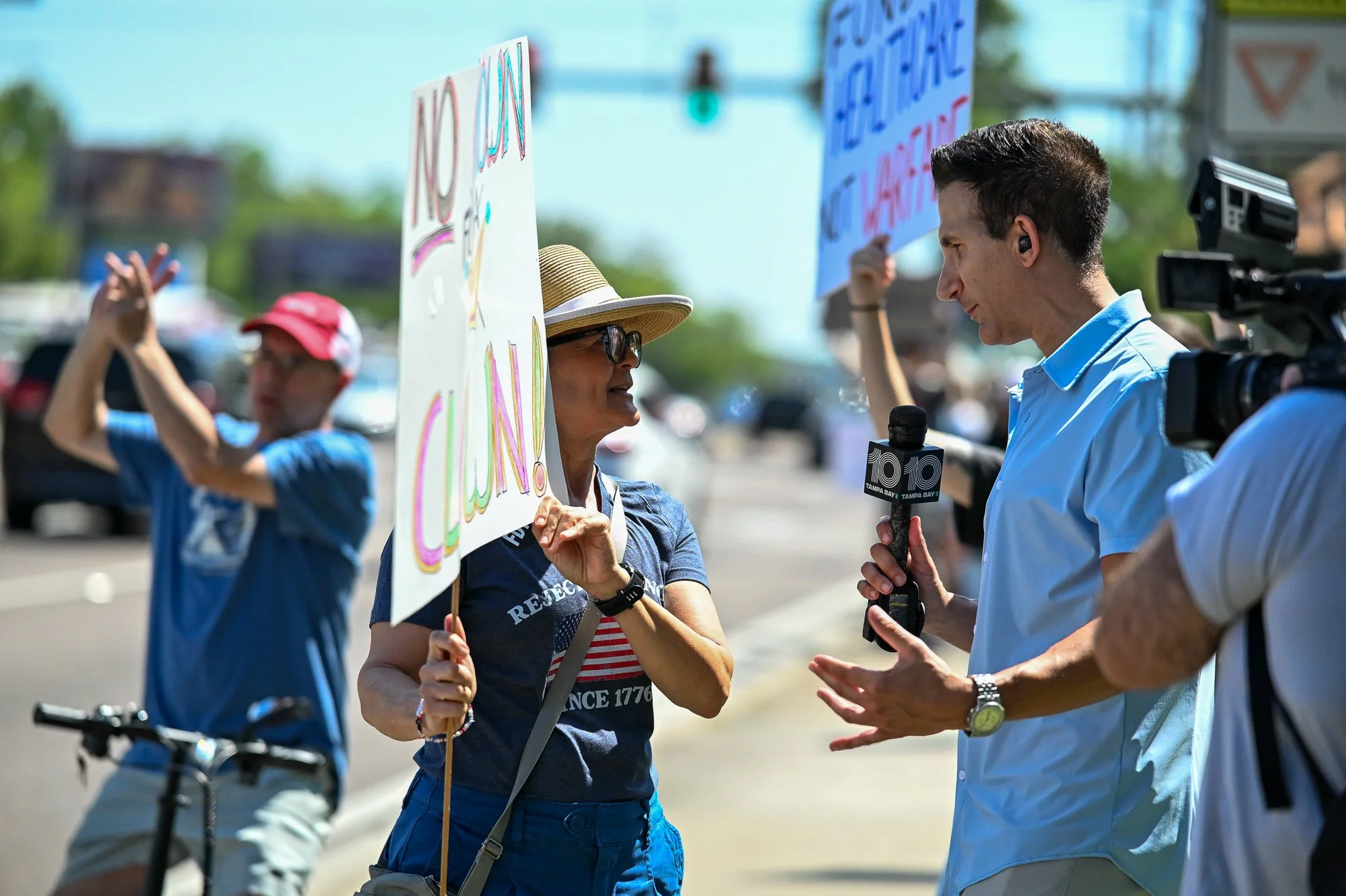 Local news interviewing protestor holding signs at No Kings event in Largo during Street Photography session